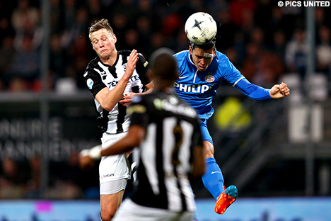 Karim Rekik - met pleister boven zijn oog - kopt de bal weg.