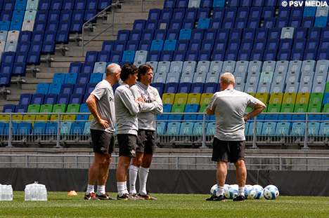 De staf met de trainers Van der Weerden en Faber tijdens de warming-up.