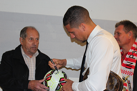Jeffrey Bruma zet zijn handtekening op de wedstrijdbal.