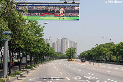 Boven deze lange weg hangen grote foto's van de Koreaan.