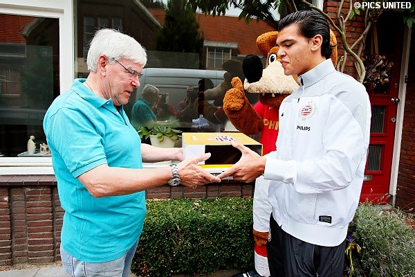 Deze jarige fan neemt een taart van Karim Rekik dankbaar in ontvangst.